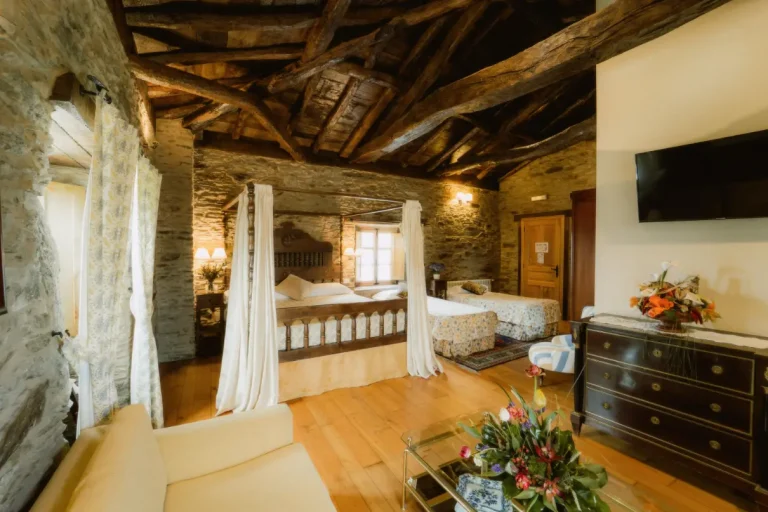 Habitación del pazo de santamaría con cama grande y dos pequeñas